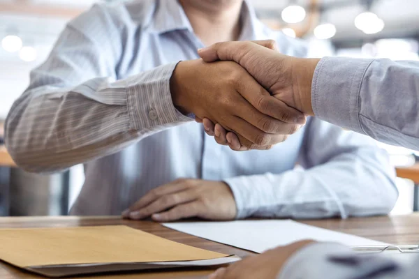 Finishing up a meeting, handshake of two happy business people after contract agreement to become a partner, collaborative teamwork.