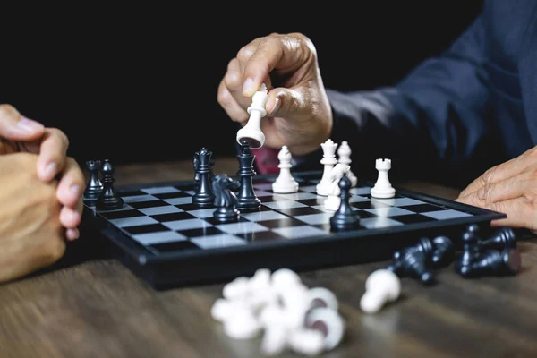 Businessman and businesswoman playing chess and thinking about strategy crash overthrow the opposite team and development analysis for win and successful.