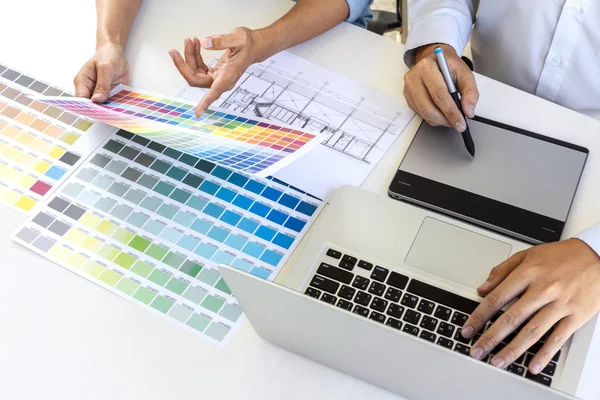 Takım çizim ve rötuş meslektaşım grafik tasarımcı grafik tablet üzerinde görüntü ve renk renk örneği örnekleri dizüstü bilgisayar üzerinde seçim için seçin.