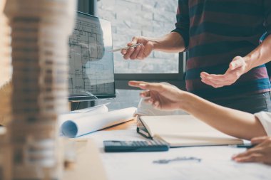 Mimar veya inşaat mühendislik ekibi planı denetim işyerinde, çizim ve toplantı için ortak çalışma mimari proje çizimi üzerinde çalışmaya eller.