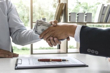 Anlaşma, rüşvet ve yolsuzluk kavramı vermek başarı süre elinde işadamı el sıkışma para dolar faturaları.