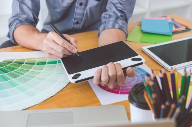 Genç yaratıcı grafik tasarımcı çalışma proje mimari çizim ve renk örnekleri, iş araçları ve ekipmanları ile grafik grafik üzerinde boyama seçimi hakkında.