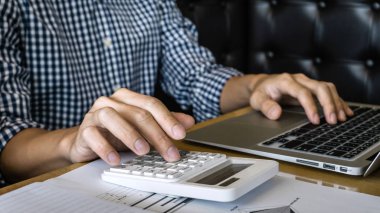 İşadamı muhasebeci çalışma denetim ve grafik belgeleri, çalışma alanı'ndaki finans yapıyor hesaplamak gider finansal veriler.