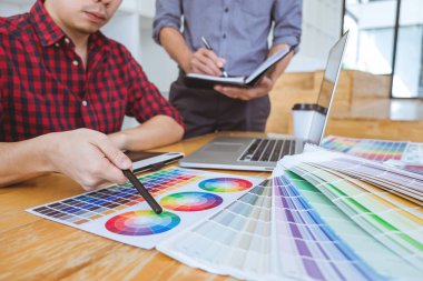 Toplantı yaratıcı grafik tasarımcı takım seçimi seçim yeni projede çalışan iş araçları ve aksesuarları ile tablet renk ve grafik çizim.