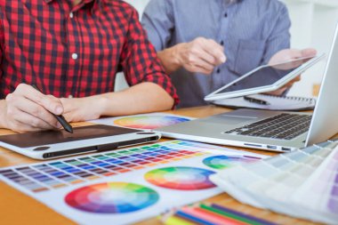 Toplantı yaratıcı grafik tasarımcı takım seçimi seçim yeni projede çalışan iş araçları ve aksesuarları ile tablet renk ve grafik çizim.