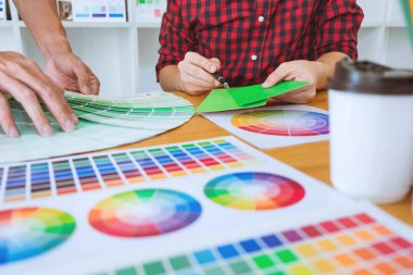 Ekip çalışması üzerinde çalışan genç yaratıcı tasarımcılar birlikte proje ve çalışma alanı, dijital grafik tablet boyama seçimi için renk renk örneği örnekleri seçin.