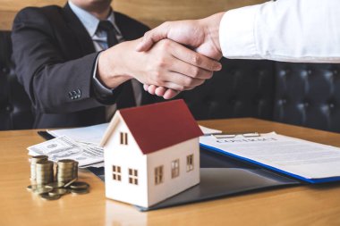 Gayrimenkul, Broker ve sözleşme imzaladıktan sonra el sıkışan istemci başarılı anlaşma görüntüsünü ipotek kredi teklif için ve ev sigortası ile ilgili başvuru formu onaylı.