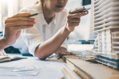 Mimar veya inşaat mühendislik ekibi planı denetim işyerinde, çizim ve toplantı için ortak çalışma mimari proje çizimi üzerinde çalışmaya eller.
