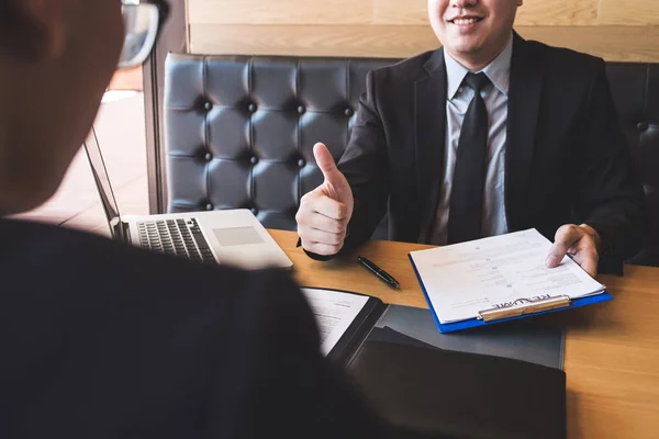 Employer or recruiter holding reading a resume during about his profile of candidate, employer in suit is conducting a job interview, manager resource employment and recruitment concept.