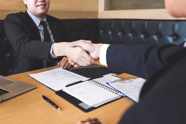 Successful job interview with boss and employee shaking hands after negotiation or interview, career and placement concept.