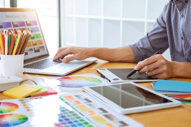 Genç yaratıcı grafik tasarımcı çalışma proje mimari çizim ve renk örnekleri, iş araçları ve ekipmanları ile grafik grafik üzerinde boyama seçimi hakkında.