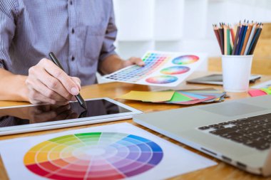 Genç yaratıcı grafik tasarımcı çalışma proje mimari çizim ve renk örnekleri, iş araçları ve ekipmanları ile grafik grafik üzerinde boyama seçimi hakkında.