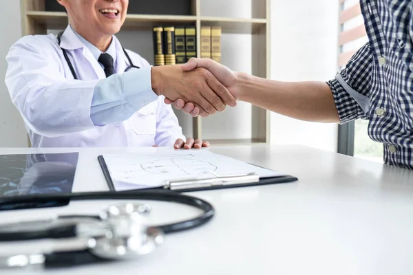 Professor Doctor having shaking hands with patient after recommend treatment method while discussing explaining his symptoms or counsel diagnosis health, healthcare and assistance concept.