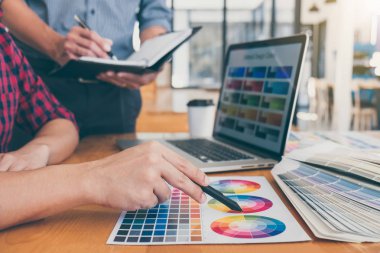 Ekip çalışması üzerinde çalışan genç yaratıcı tasarımcılar birlikte proje ve çalışma alanı, dijital grafik tablet boyama seçimi için renk renk örneği örnekleri seçin.
