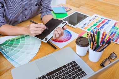 Genç yaratıcı grafik tasarımcı çalışma proje mimari çizim ve renk örnekleri, iş araçları ve ekipmanları ile grafik grafik üzerinde boyama seçimi hakkında.