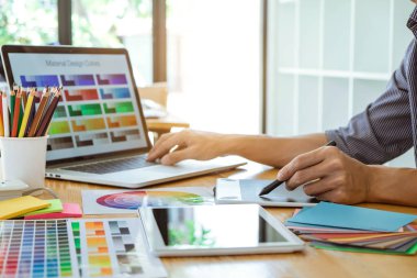 Genç yaratıcı grafik tasarımcı çalışma proje mimari çizim ve renk örnekleri, iş araçları ve ekipmanları ile grafik grafik üzerinde boyama seçimi hakkında.