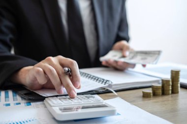 İşadamı muhasebeci sayım para ve mali yapıyor rapor ve çözümleme finansal veri, muhasebe bankacılık kavramı finansman ve yatırım maliyeti hakkında hesaplamak notlara yapma.