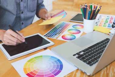 Genç yaratıcı grafik tasarımcı çalışma proje mimari çizim ve renk örnekleri, iş araçları ve ekipmanları ile grafik grafik üzerinde boyama seçimi hakkında.