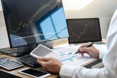 Borsa konsepti, borsa simsarı ekran ekranı ile çalışan ve analiz eden borsacı, sunulan verilere işaret ediyor ve bir borsada anlaşma yapıyor, iş adamı çevrimiçi hisse senedi ticareti yapıyor.