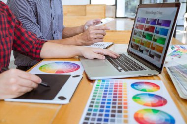 Toplantı yaratıcı grafik tasarımcı takım seçimi seçim yeni projede çalışan iş araçları ve aksesuarları ile tablet renk ve grafik çizim.