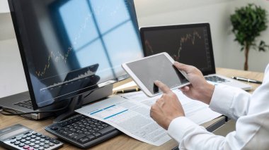 Borsa konsepti, borsa simsarı ekran ekranı ile çalışan ve analiz eden borsacı, sunulan verilere işaret ediyor ve bir borsada anlaşma yapıyor, iş adamı çevrimiçi hisse senedi ticareti yapıyor.