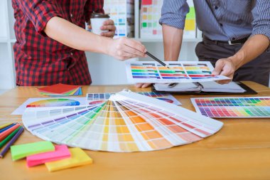 Ekip çalışması üzerinde çalışan genç yaratıcı tasarımcılar birlikte proje ve çalışma alanı, dijital grafik tablet boyama seçimi için renk renk örneği örnekleri seçin.