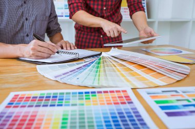 Ekip çalışması üzerinde çalışan genç yaratıcı tasarımcılar birlikte proje ve çalışma alanı, dijital grafik tablet boyama seçimi için renk renk örneği örnekleri seçin.