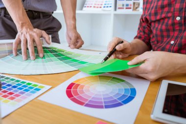 Ekip çalışması üzerinde çalışan genç yaratıcı tasarımcılar birlikte proje ve çalışma alanı, dijital grafik tablet boyama seçimi için renk renk örneği örnekleri seçin.