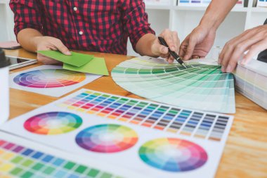 Ekip çalışması üzerinde çalışan genç yaratıcı tasarımcılar birlikte proje ve çalışma alanı, dijital grafik tablet boyama seçimi için renk renk örneği örnekleri seçin.