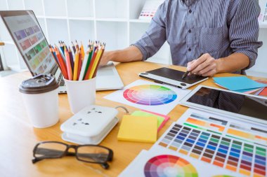 Genç yaratıcı grafik tasarımcı çalışma proje mimari çizim ve renk örnekleri, iş araçları ve ekipmanları ile grafik grafik üzerinde boyama seçimi hakkında.
