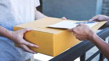 Posta teslimatçı parsel kutusu veren alıcı ve imza formu, Genç sahibi paketi yazı sevkiyat kurye, eve teslim hizmet ve hizmet zihin ile çalışma alınmasından imzalama.