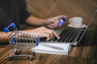 Kredi kartı tutan ve laptop için online yazarak işadamı 