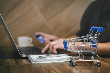 Kredi kartı tutan ve laptop için online yazarak işadamı 