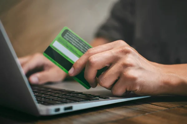 Бізнесмен тримає кредитну картку і друкує на ноутбуці онлайн — стокове фото