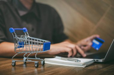 Kredi kartı tutan ve laptop için online yazarak işadamı 