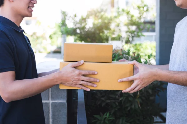 El hombre del correo de entrega que da la caja del paquete al destinatario, dueño joven ac —  Fotos de Stock