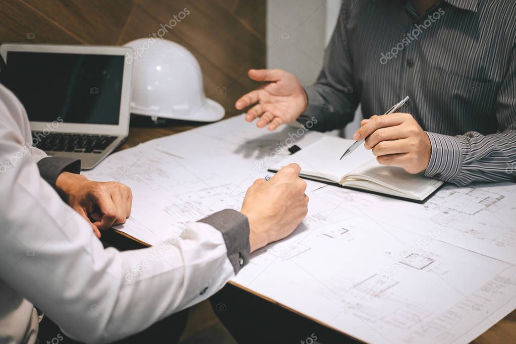 Construction engineering or architect discuss a blueprint while 
