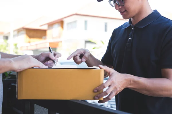 Delivery mail man giving parcel box to recipient, Young man sign