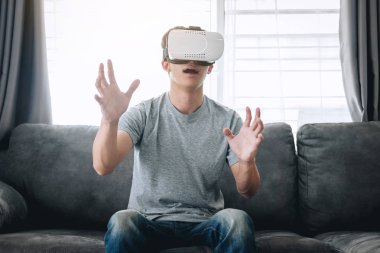 Young asian man having fun wearing playing virtual reality heads