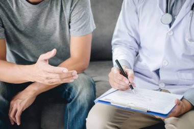 Beyaz üniformalı önlük lü profesyonel doktor ve hasta discu