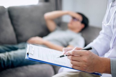 Beyaz üniformalı önlüklü doktor ve mutsuz hasta tartışıyor