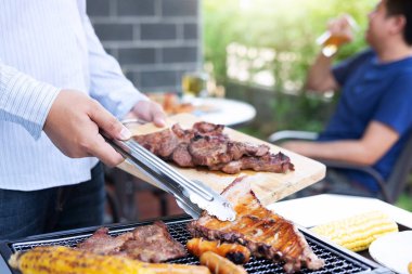 Arkadaş Grubu Izgara et zevk iki genç adam ve yükseltmek