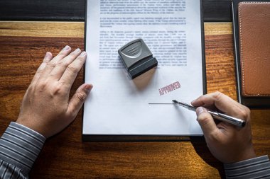 İş işadamı imzalama ve kağıt belgeli damga ellerini yakın