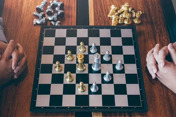 Intelligent businessman playing chess game competition with the