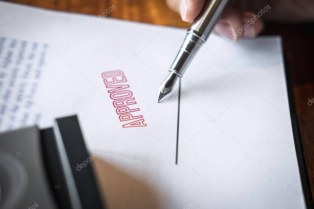 Close up hands of businessman signing and stamp on paper documen
