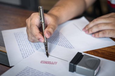 İş işadamı imzalama ve kağıt belgeli damga ellerini yakın