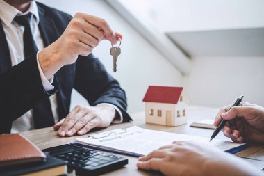 Sözleşmenin imzalanmasından sonra istemciye evin anahtarları veren emlakçı