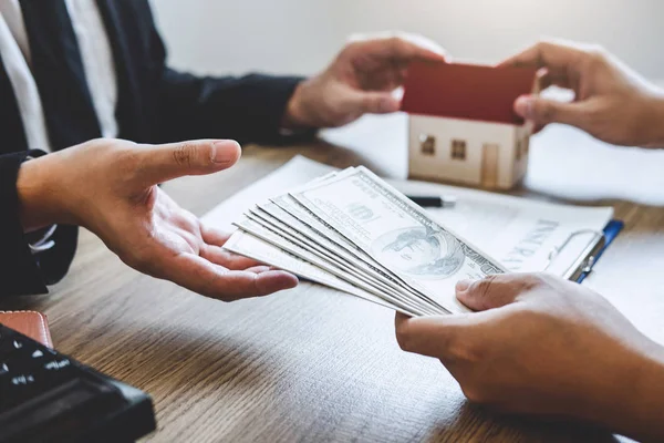 Агент по недвижимости дает дом и ключи клиенту после подписания договора — стоковое фото