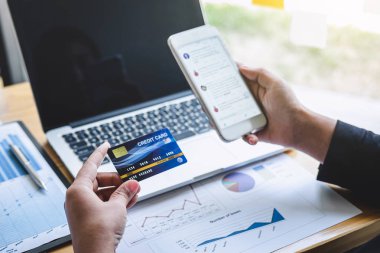 İş kadını tüketici akıllı telefon, kredi kartı ve typi tutan