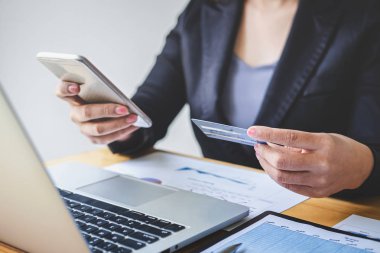 İş kadını tüketici akıllı telefon, kredi kartı ve typi tutan